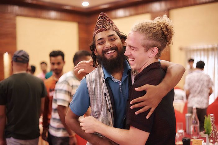 Two guests laughing and hugging