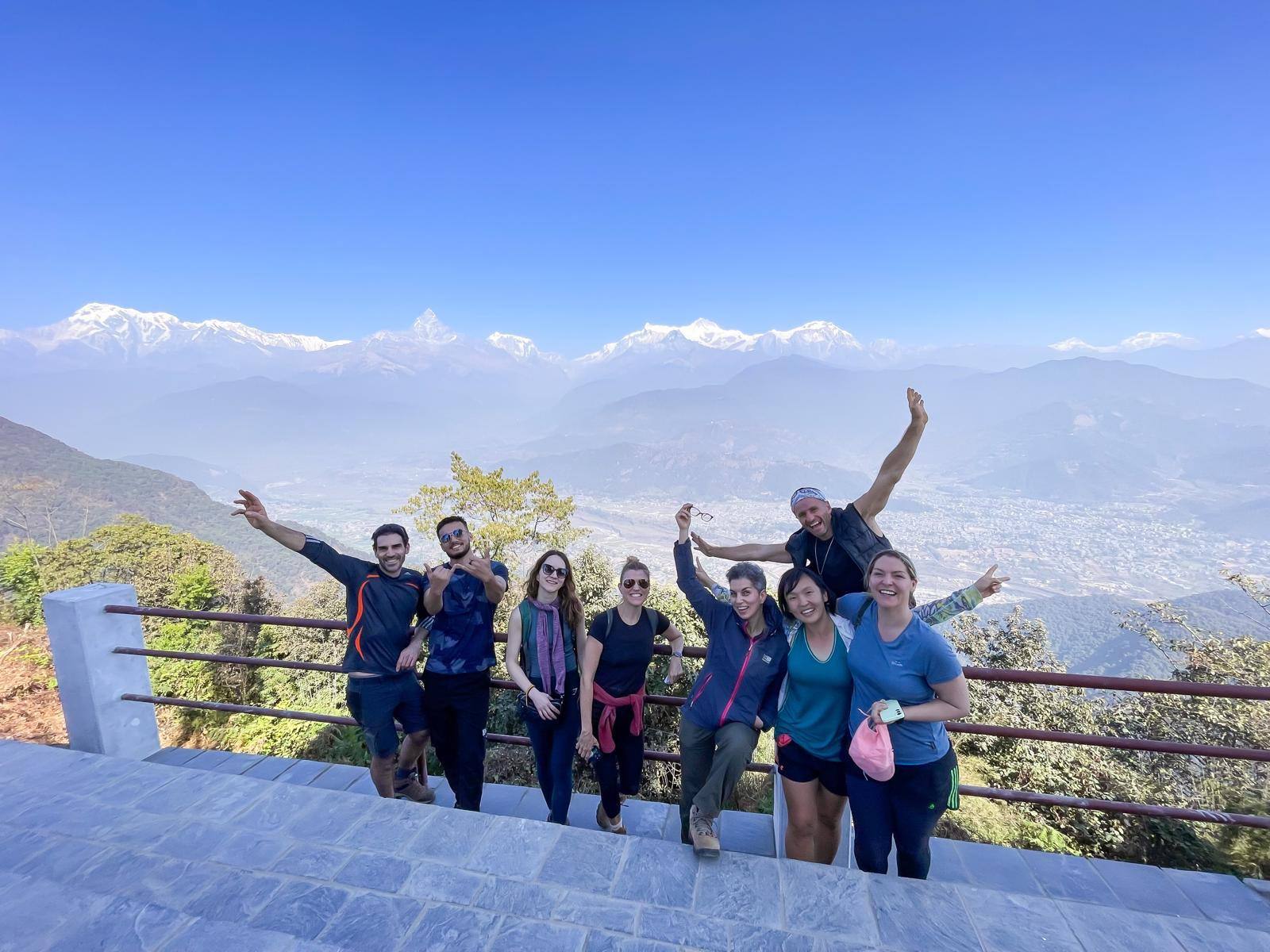 Guests celebrating on a hilltop with the Annapurna range behind