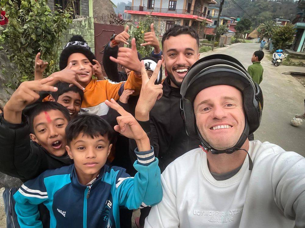 Guests on a scooter ride with local kids